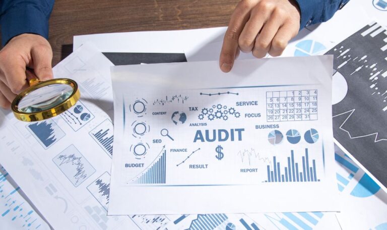 A professional workspace displaying financial charts and audit documents used by a tax consultant in dubai