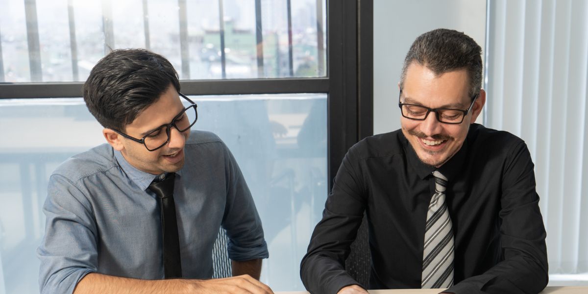 Businessmen consulting a tax consultant in dubai to discuss the key differences between VAT and corporate tax.